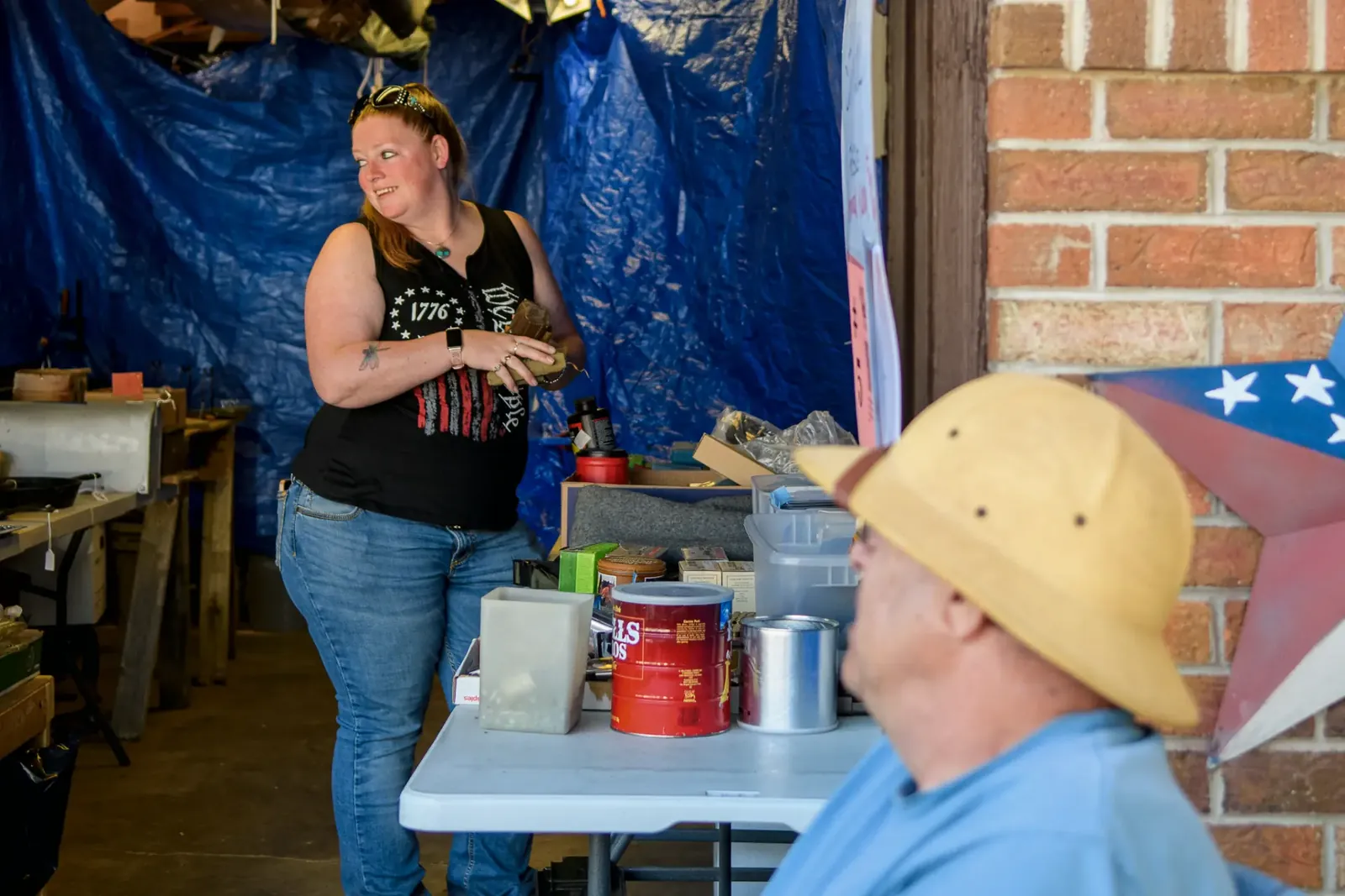 Vendor talking with a visitor beside a market table