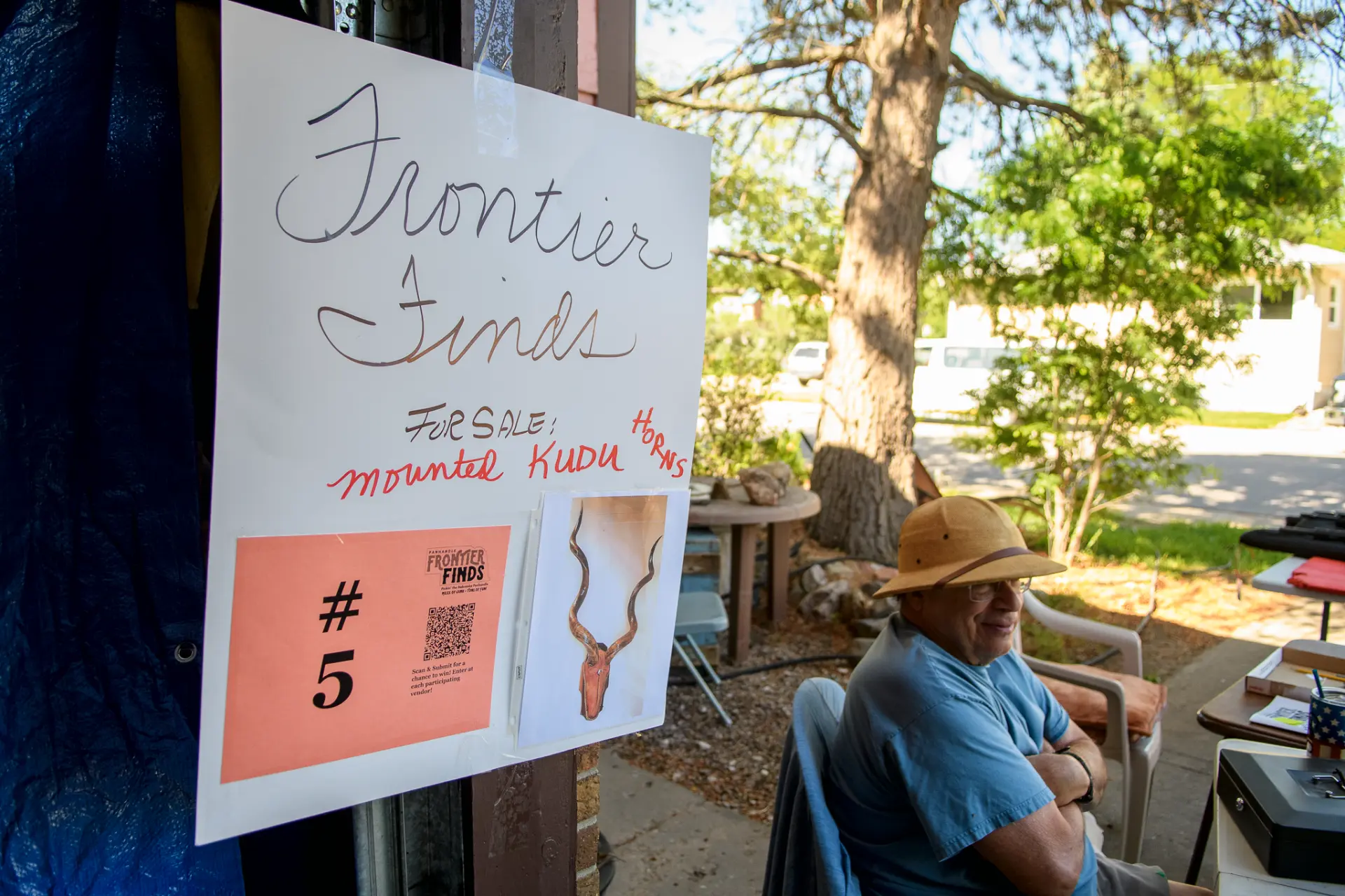 Handwritten Frontier Finds sale sign at an outdoor vendor booth
